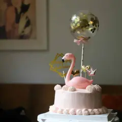 Różowy tort z flamingiem i złotym balonem z konfetti. Inspiracja, jak udekorować tort na przyjęcie.