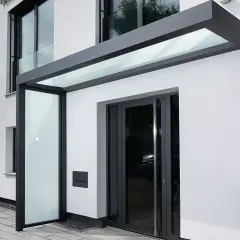 Moderne Ideen für ein Vordach am Hauseingang: Glas und Anthrazit schaffen einen eleganten Schutz.