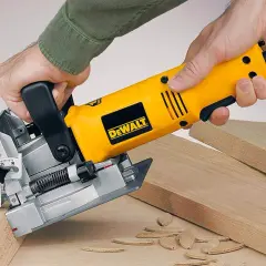 Main jaune DeWalt, une lamelleuse, utilisée pour assembler des planches de bois.