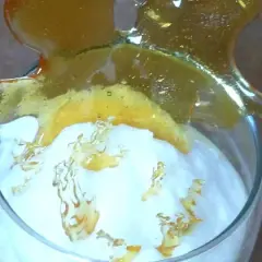 Un verre de crème aérienne surmonté d'une décoration en caramel craquant. Ces oeufs à la neige sont prêts à être dégustés.