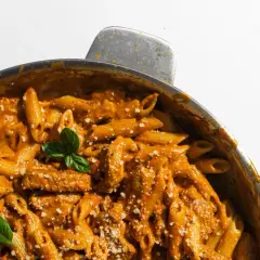 En krämig pasta i ugn med kyckling och en smakrik tomatsås, toppad med färsk basilika och parmesan.