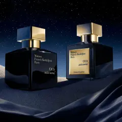 Dwa luksusowe flakony perfum Maison Francis Kurkdjian OUD satin mood na tle nocnego, gwieździstego nieba i piaszczystych wydm.