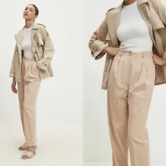 Eleganckie spodnie dla starszych pań w beżowym kolorze, z modnymi zakładkami. Idealne do stylowych, codziennych zestawów.