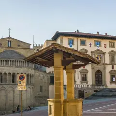 Piazza Grande ad Arezzo, con la Pieve di Santa Maria Assunta e il Palazzo dei Priori. Un luogo perfetto per scoprire le cose da fare ad Arezzo.