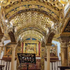 Interior de una capilla ricamente decorada con techos abovedados dorados y azules, pinturas y un altar. Caminos de pasión que invitan a la contemplación.