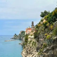 Coastal view of Amalfi with a church tower. Consider a ferry or bus for how to get from Amalfi to Naples.