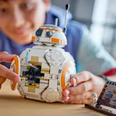 Chłopiec składa największy zestaw LEGO Star Wars - droida BB-8. Obok stoi mniejsza figurka.