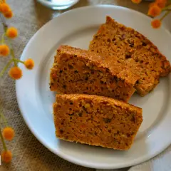 Rebanadas de bizcocho de zanahoria casero, esponjoso y con trocitos de zanahoria visibles, servidas en un plato blanco.