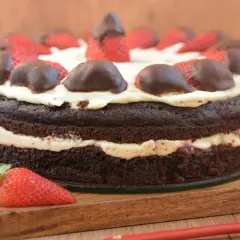 Obłędny tort czekoladowy z mascarpone i owocami. Puszyste ciasto przełożone kremem, ozdobione truskawkami w czekoladzie.