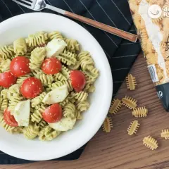 Ensalada de pasta al pesto con tomates cherry y mozzarella fresca. Un plato ligero y delicioso.