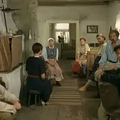 Scena z filmu "Znachor", gdzie nagrywali w wiejskiej chacie. Ludzie siedzą w skromnym wnętrzu, czekając na pomoc.