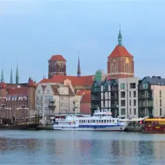 Statek wycieczkowy "Gryf" płynie przez Gdańsk, mijając zabytkowe kamienice i kościoły.