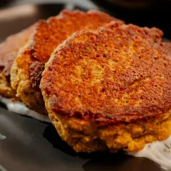 Trois galettes dorées de tortilla pois chiche, servies sur une sauce blanche crémeuse.
