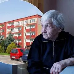 Starsza pani spogląda przez okno na blok mieszkalny, być może zastanawiając się nad swoim dodatkiem mieszkaniowym.