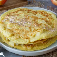 Ein Stapel goldbrauner Apfelpfannkuchen, bestäubt mit Puderzucker. Ein köstliches Apfelpfannkuchen Rezept für jeden Anlass.