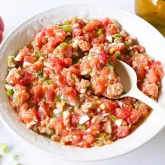 Un plato de pipirrana de Jaén, una ensalada fresca de tomate, pimiento y huevo, lista para disfrutar.