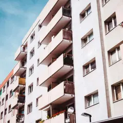 Jasny budynek z wieloma balkonami, idealny dla kogoś, kto szuka mieszkania na parterze.
