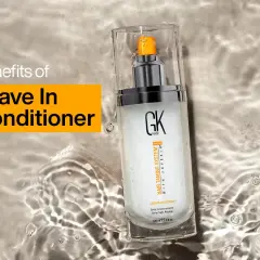 Un spray leave in para el cabello GK Hair, que promete beneficios para el pelo, descansa sobre una superficie con agua.