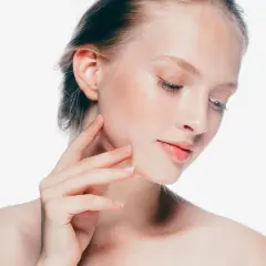 Delikatna skóra młodej kobiety, jej herla dotyka policzka, podkreślając naturalne piękno.