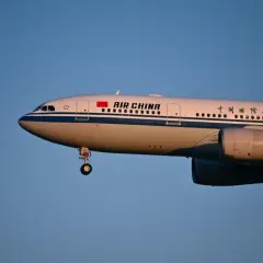 Samolot Air China z wysuniętym podwoziem, gotowy do lądowania. Wiele osób szuka pozytywnych air china opinie przed podróżą.