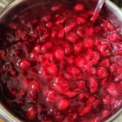 Gęsta, błyszcząca frużelina wiśniowa w metalowym garnku, gotowa do podania.