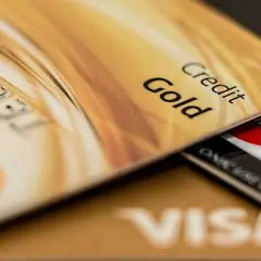 Cartes de crédit dorées, dont une "Gold", superposées. Pensez aux frais bancaires au Portugal pour ces paiements.