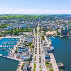 Gdynia o wszystkim: port jachtowy, plaża, nowoczesne budynki i zielone wzgórza. Widok z lotu ptaka na tętniące życiem miasto nad Bałtykiem.