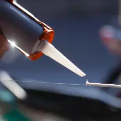 Aplikacja silikonu na zewnątrz, tworząc cienką, równą linię na szkle.