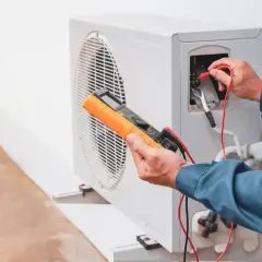Un technicien vérifie une pompe à chaleur, une solution moderne pour remplacer le chauffage électrique.