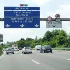 Sur l'autoroute A35, des panneaux indiquent Offenburg, Mulhouse et la Porte Blanche. Des voitures circulent par une journée nuageuse.