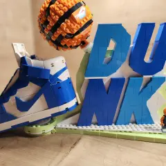 Lego-Nachbau eines Nike Dunk Sneakers mit Basketball und dem Wort "DUNK" aus bunten Lego-Steinen.