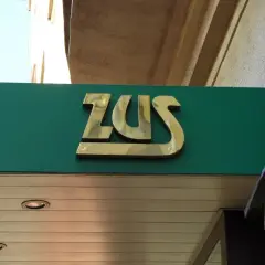 Złote logo ZUS na zielonym tle. Może to miejsce, gdzie załatwisz świadczenie urlopowe.