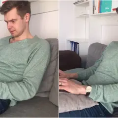 Mężczyzna w swetrze siedzi w **pozycji półleżącej** na kanapie, pracując na laptopie.