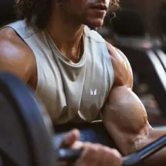 Mann im Fitnessstudio trainiert Bizeps, um dicke Arme zu bekommen.
