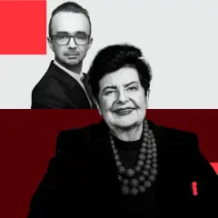 Uśmiechnięta kandydatka po na prezydenta, z mężczyzną w okularach w tle.