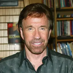 Chuck Norris, którego wiek nie ma znaczenia, bo jest niezniszczalny, pozuje na tle swoich książek.