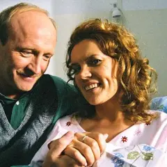 Szczęśliwa para, on w fartuchu, ona w szpitalnej koszuli, trzymają się za ręce. To ich całkiem nowe lata miodowe.