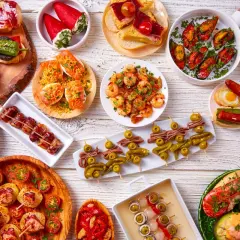 Pyszne hiszpańskie jedzenie: tapas z krewetkami, małżami, paprykami, oliwkami i innymi przysmakami.