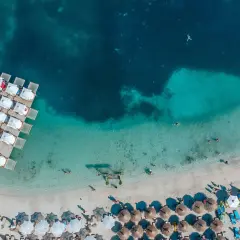 En strand med turkost vatten och solstolar, som påminner om Europas Maldiverna i Albanien.