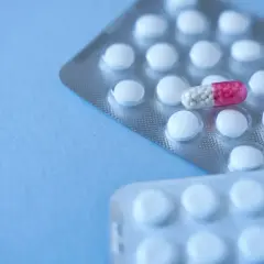 Blister opakowań tabletek, jedna kapsułka z różowym czubkiem. Clonazepam na co? Na niepokój, bezsenność.
