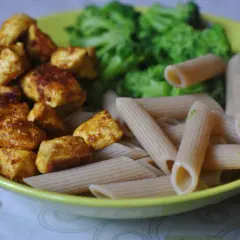 Szybkie przepisy na dania w 15 minut: kurczak w przyprawach, makaron penne i brokuły na talerzu.