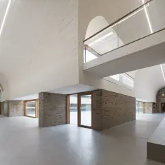 Modernes Haus Altenberg mit geschwungener Decke, Ziegelwänden und viel Glas.