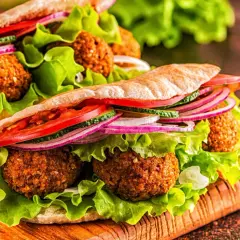 Pyszne falafel w picie z sałatą, pomidorem, ogórkiem i czerwoną cebulą. Idealna przekąska, która odpowie na pytanie: co to jest falafel?