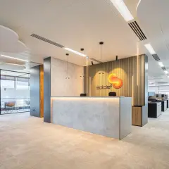 Recepción moderna con logo de "soldef" y mobiliario elegante. El diseño busca crear un ambiente de trabajo que inspire y funcione bien.