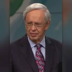 Porträt von Dr. Charles Stanley, einem älteren Mann mit Brille und grauem Haar, der einen Anzug mit gemustertem Krawatte trägt.