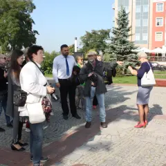 Grupa osób po francusku, przewodnik pokazuje drogę.