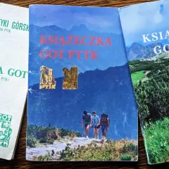 Trzy okładki książeczek GOT PTTK z odznakami. Jedna biała z zielonymi symbolami, dwie z górskimi krajobrazami i turystami.