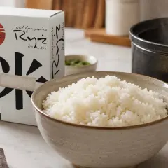 Gotowy ryż do sushi w misce, obok opakowanie ryżu i garnek. Idealny sposób, jak ugotować ryż do sushi.