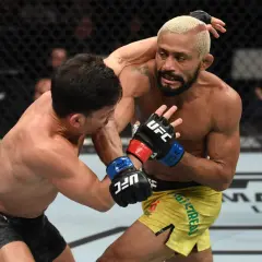 Two fighters in a flyweight weight bout exchange punches in the octagon.