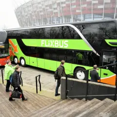 Dwa autokary Flixbus i PolskiBus stoją obok siebie.